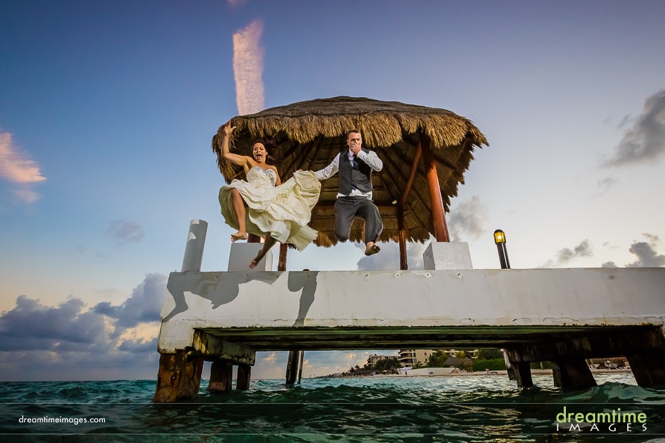 wedding couple jumping into ocean