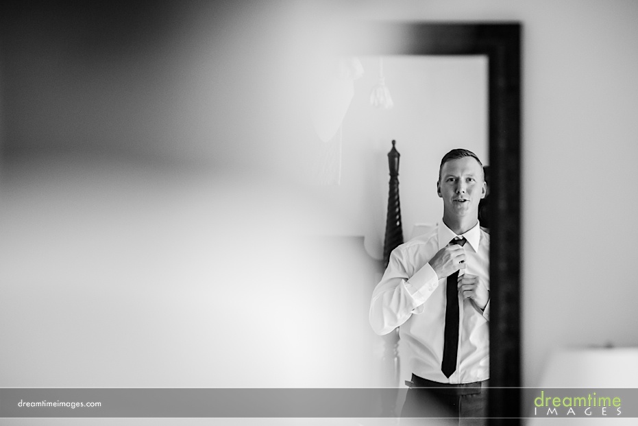 groom putting on tie